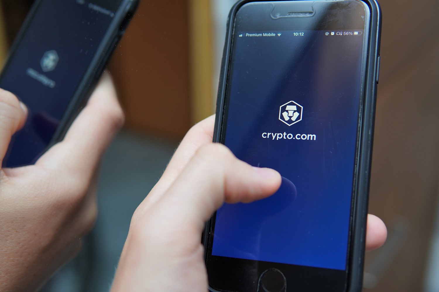 man holding mobile phone with Crypto.com on phone screen