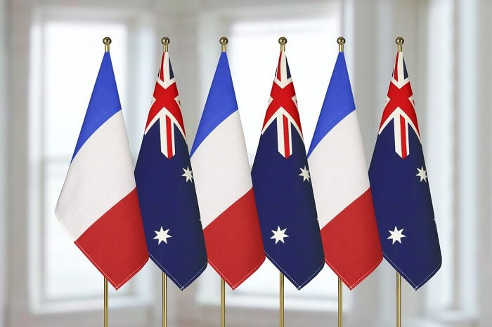 French and Australian flags standing in white room