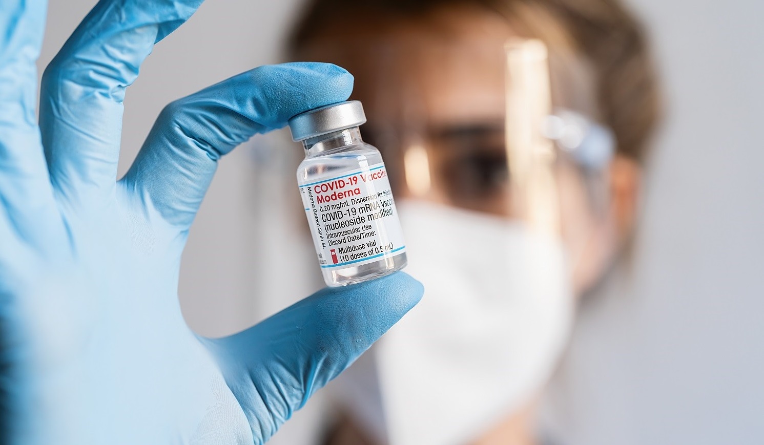 Scientist holding mRNA vaccine vial